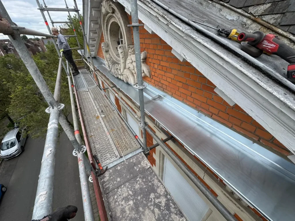 Vue d’ensemble du chéneau avant en zinc et de l’entablement restauré